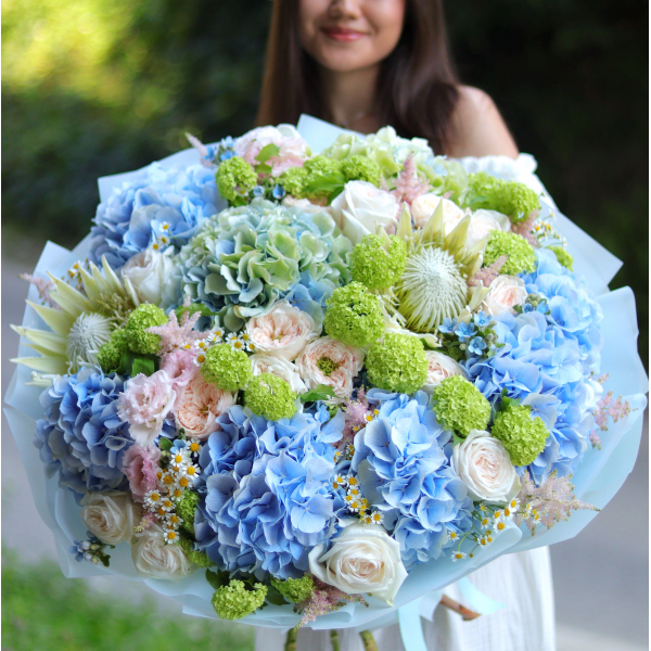 A bouquet of royal proteas, hydrangeas, peony roses and viburnum